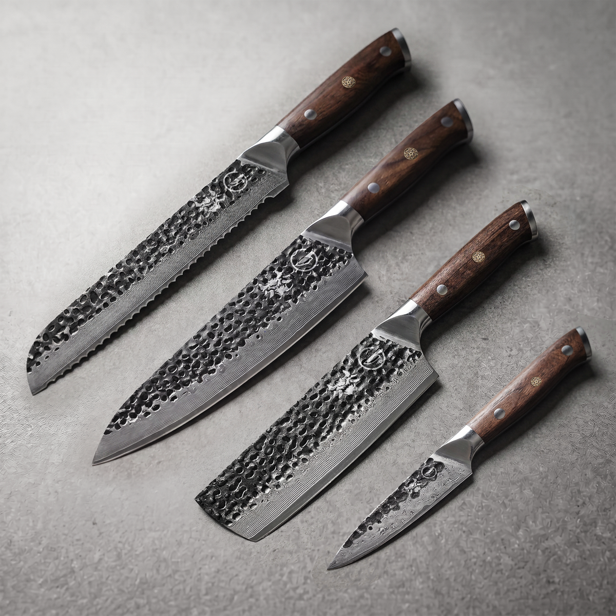 Damascus Dynasty Emperor Set: 8 inch bread, 8 inch chef, 7 inch nakiri and 4 inch paring knives laid on slate